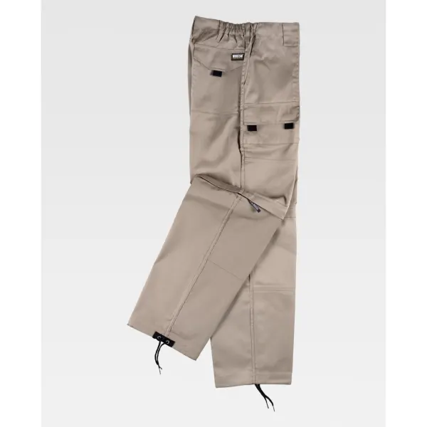 Calça desmontável com dois bolsos de fole nos costados e bolsos auxiliares sobrepostas com lapela de velcro.